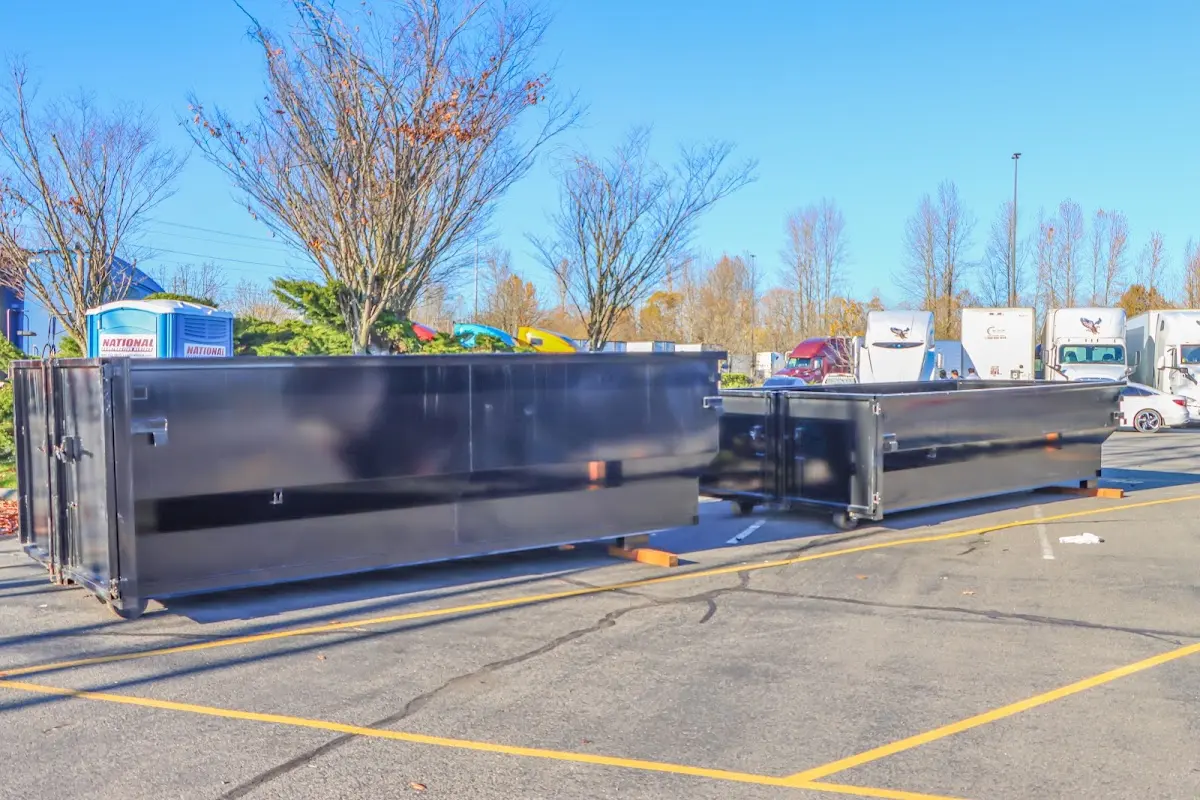 Professional dumpster rental service with roll-off container on residential driveway in Highland Park